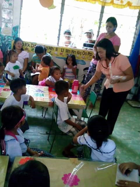 Teachings giving milk and bread in class room